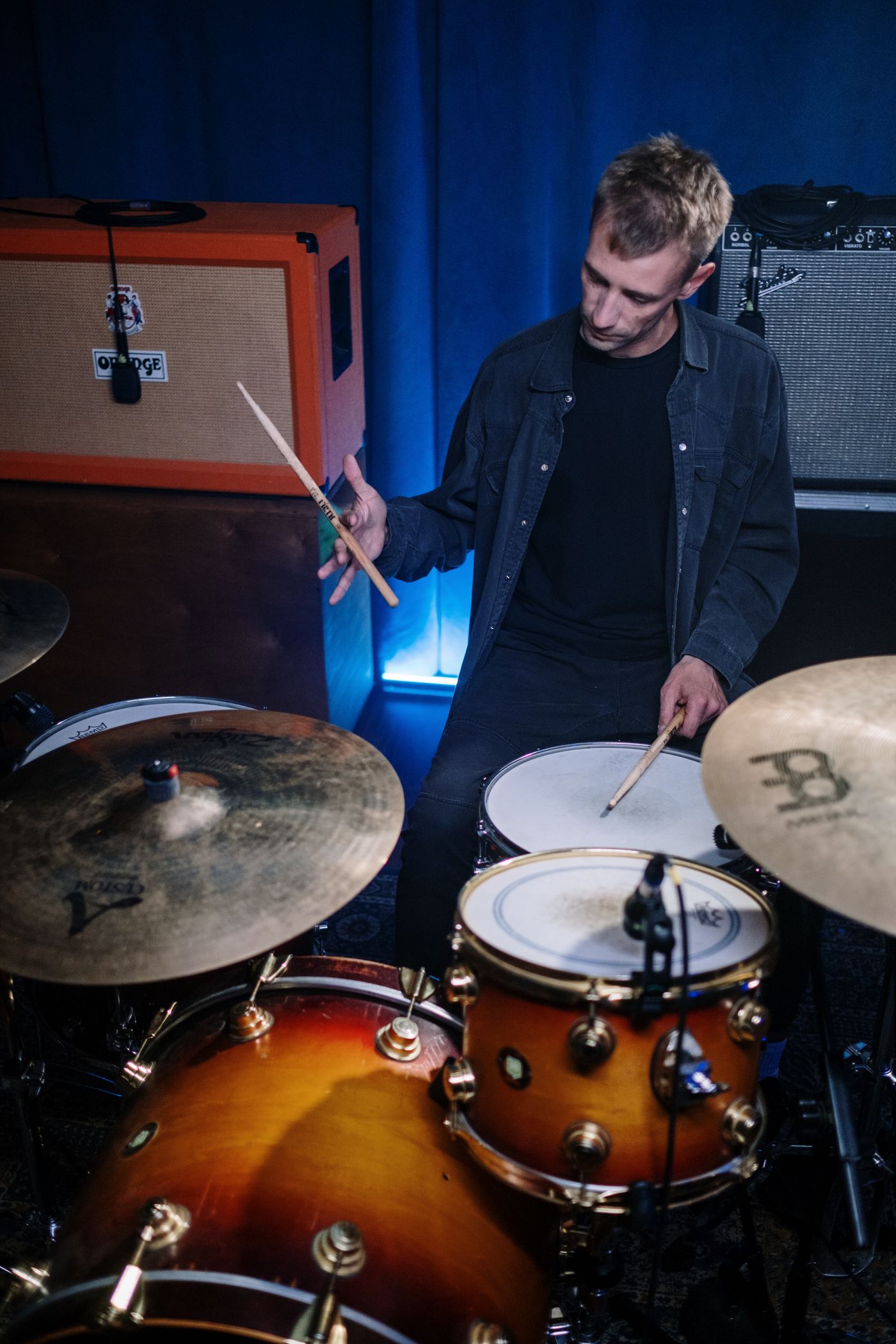 Baterista tocando em uma sala de ensaio