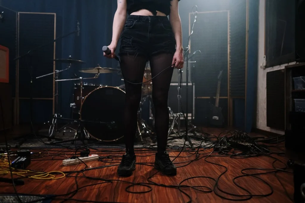 Imagem de mulher com microfone, em cima de palco.